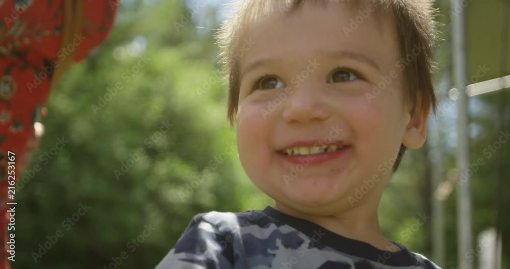 Toddler boy laughing smiling and pointing off camera - close up slow motion Toddler boy laughing smiling and pointing off camera - close up slow motion