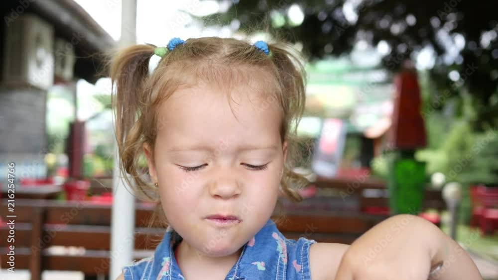 Little child girl eating with fork a sweet tasty cake with jam in restaurant Little child girl eating with fork a sweet tasty cake with jam in restaurant