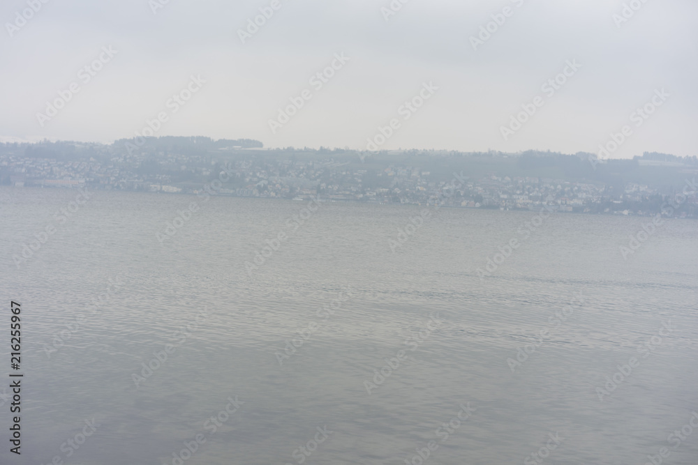 boats on lake zurich in winter with snow mountain background