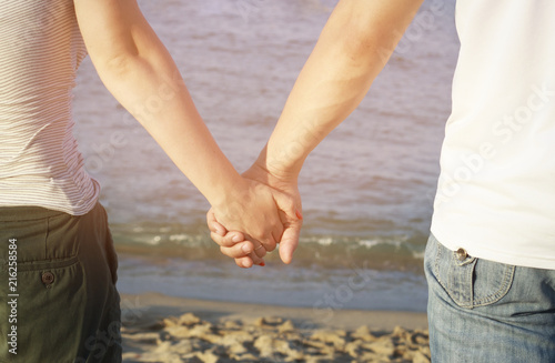 Man and woman holding hands against the sea, Toned, soft sunlight