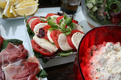 Party food - mozzarella cheese with tomato together with other food for garden party