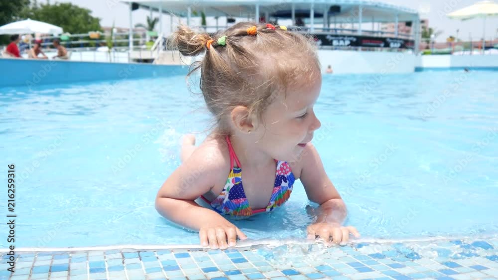 Cute little child girl have fun swim in swimming pool water at summer resort Cute little child girl have fun swim in swimming pool water at summer resort