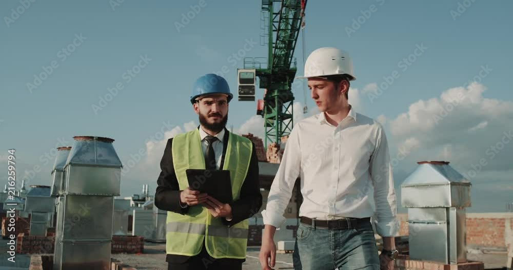 One businessman and young expert engineer analyzing on construction site the plan of a new building