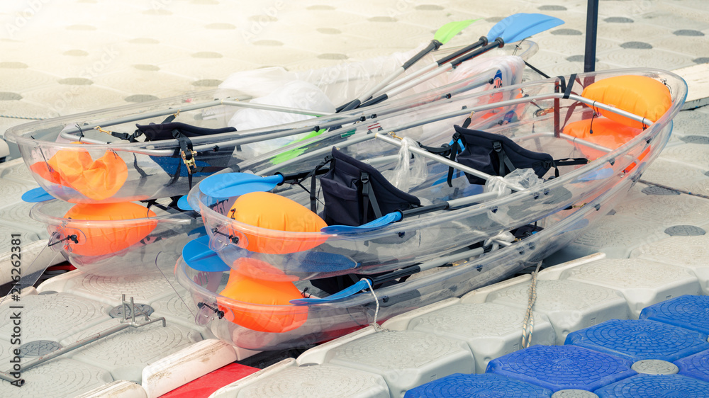 Transparent plastic canoes stay on port.