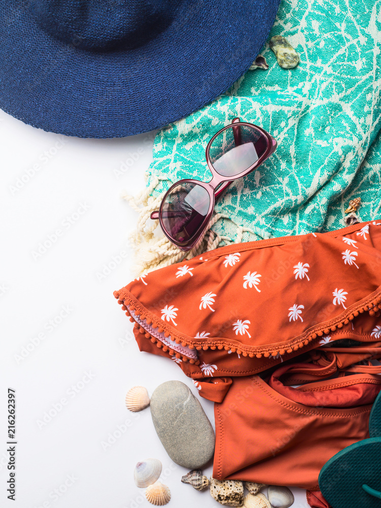 Naklejka premium Beach female fashion accessories swimsuit, sun glasses, hat, flip flops, towel and bag. Summer traveling holiday concept flat lay
