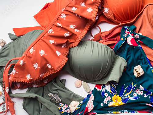 Fototapete Woman's swimsuits on white background with sea summer stones and shells