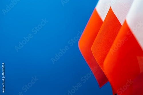 Flags of Poland with blue background empty space for your text on left. photo