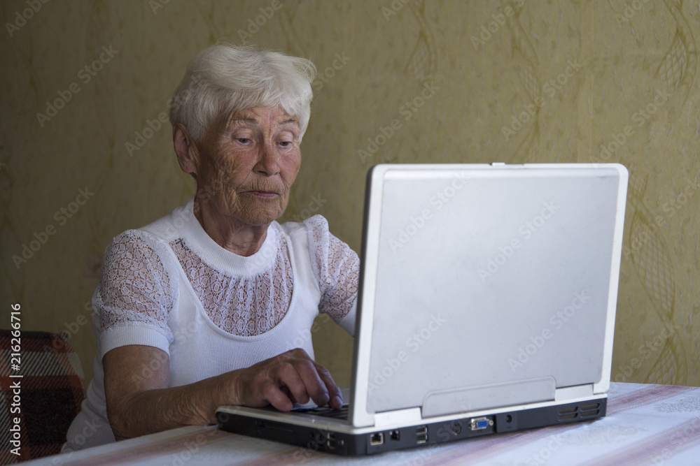 Portrait of smiling older woman working laptop computer indoors Portrait of smiling older woman working laptop computer indoors