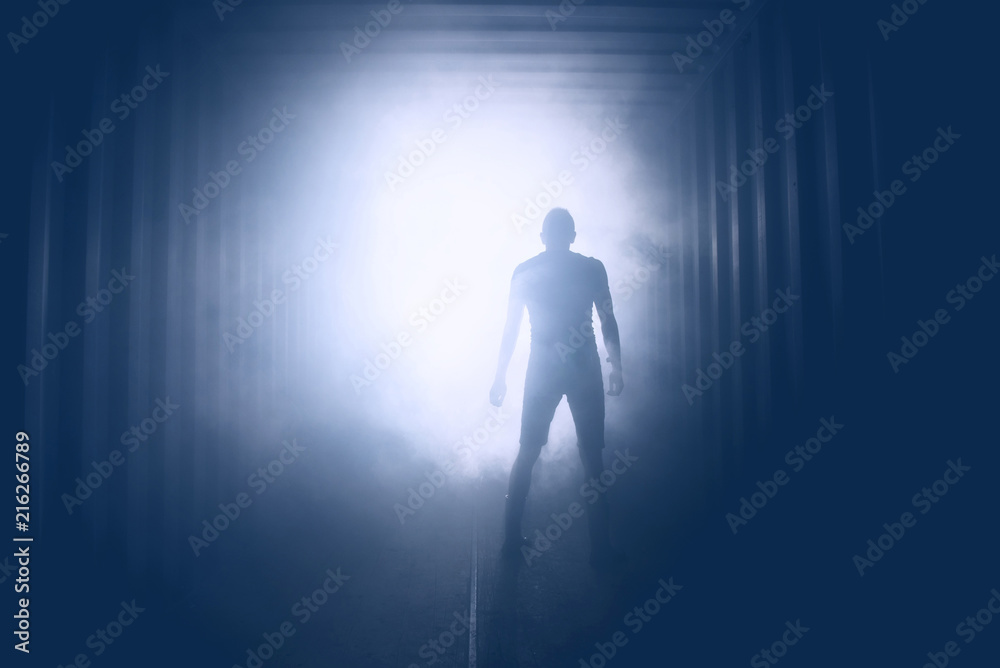 Light at the end of the tunnel. Silhouette of people in dark passage Light at the end of the tunnel. Silhouette of people in dark passage