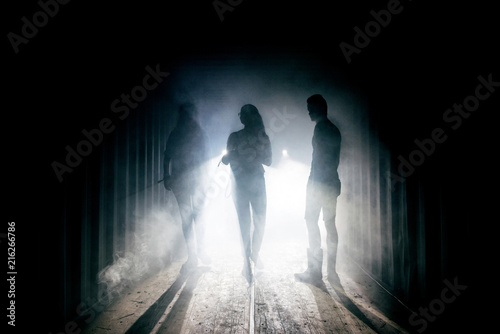 Light at the end of the tunnel. Silhouette of people in dark passage