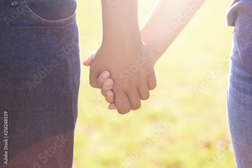 A Young Man and Woman Holding Hands Outside in the Sun © pamela_d_mcadams