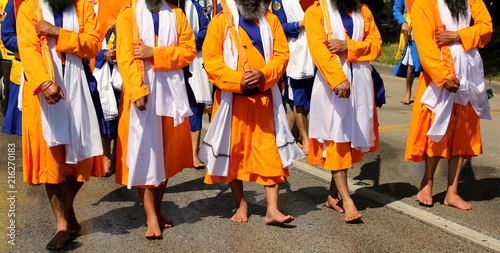 Sikh soldiers dressed in traditional orange clothes march barefo
