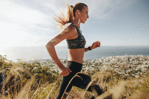 Fototapeta Naklejka Na Ścianę i Meble -  Woman training for marathon on mountain trail.