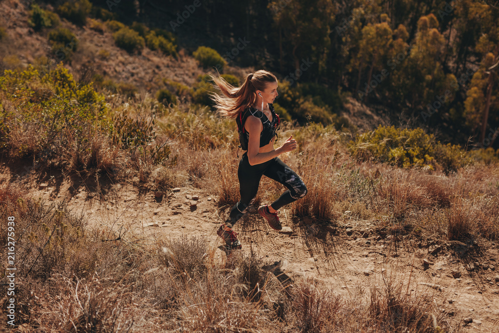 Naklejka premium Woman trail runner training for cross country run