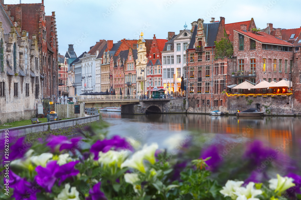 Nice view of picturesque medieval houses on the quay of Leie river and flowers, Old Town of Ghent, Belgium