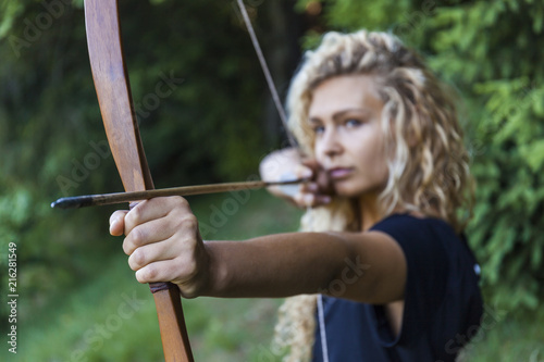 Archer aiming with her bow, close-up