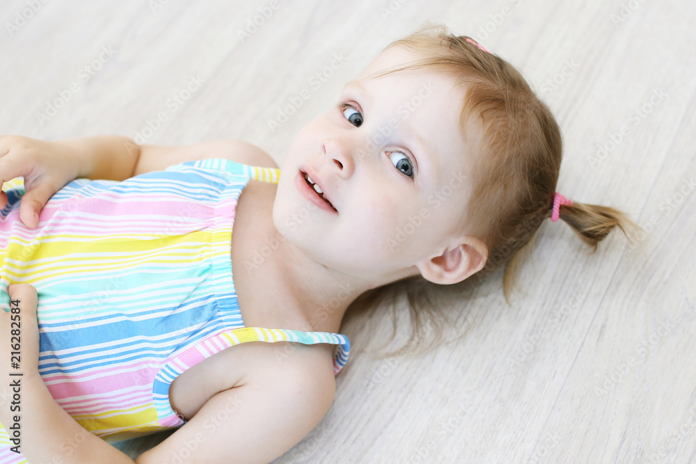 Cute little girl lying on the floor in the children's room Stock Photo ...