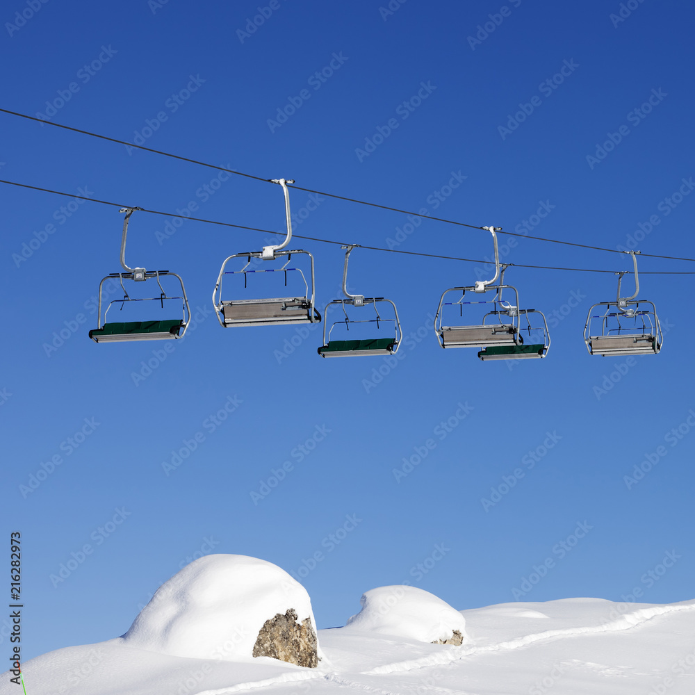 Chair-lift at ski resort at sun day after snowfall Chair-lift at ski resort at sun day after snowfall
