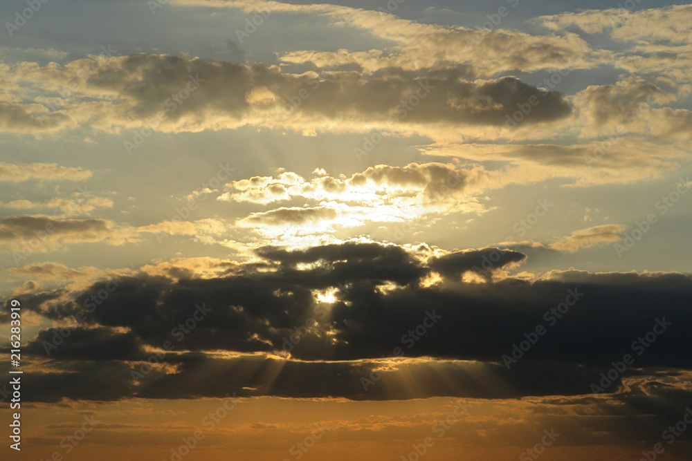 Beautiful golden sunset background with dark clouds