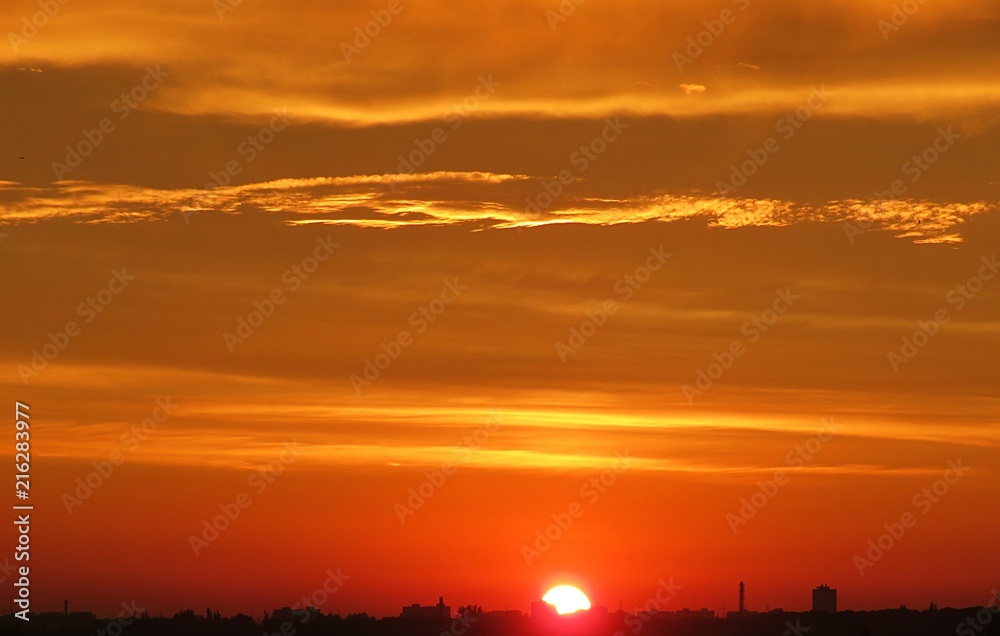 Beautiful fiery orange golden sunset background over the city 