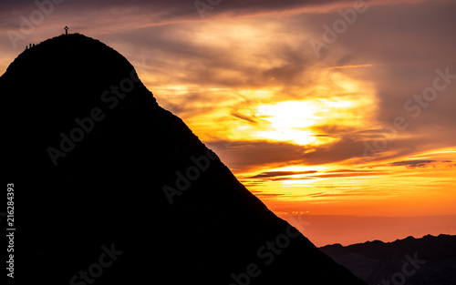 mountain peak with cross and people during sunset silhouette dramatic sunset brienzer rothorn switzerland