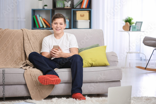 Teenage boy with smartphone...
