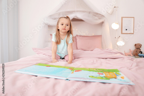 Cute little girl reading be...