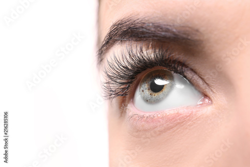 Fototapeta Naklejka Na Ścianę i Meble -  Beautiful young woman with eyelash extensions on white background, closeup