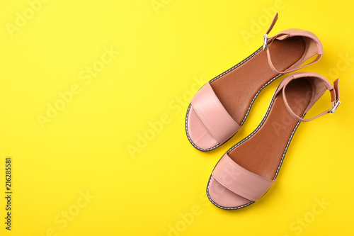 Pair of trendy women's shoes on color background, top view