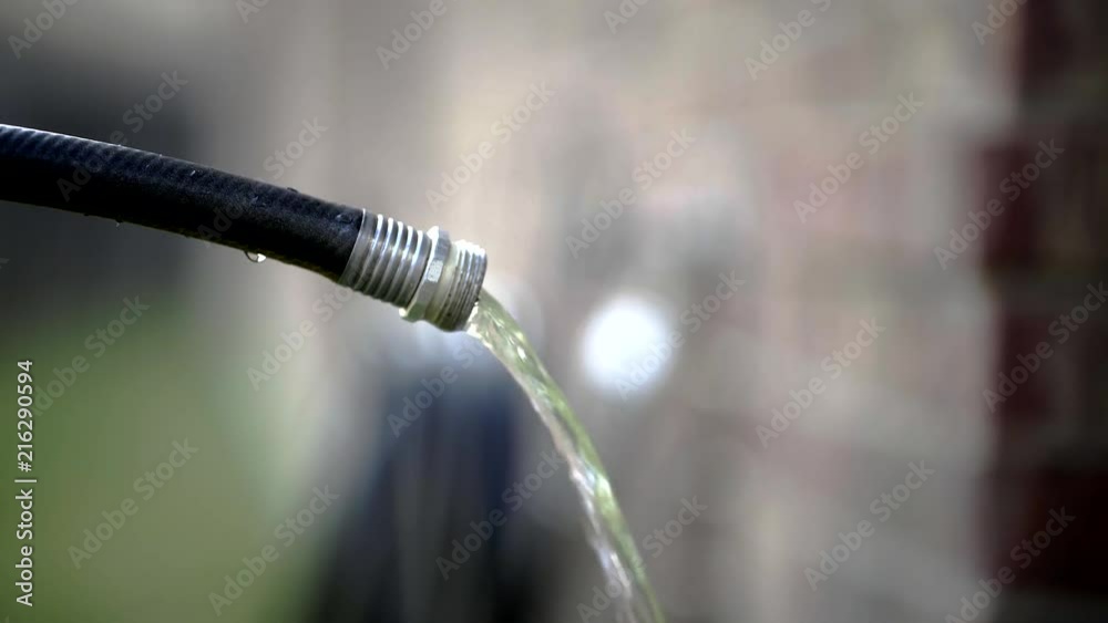 Close up of a water hose spout pouring water out. Close up of a water hose spout pouring water out.