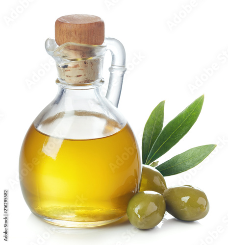 Photo Bottle of olive oil and green olives with leaves