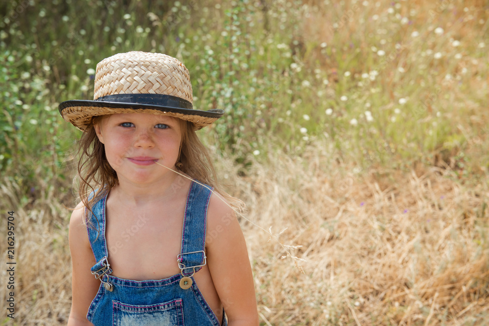 Adorable smiling child in a straw hat