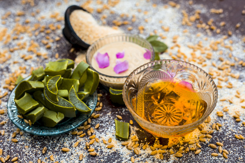 Close up of faithful home remedy for scars i.e Oats,aloevera gel and honey with some grains in surroundings on wooden surface. photo