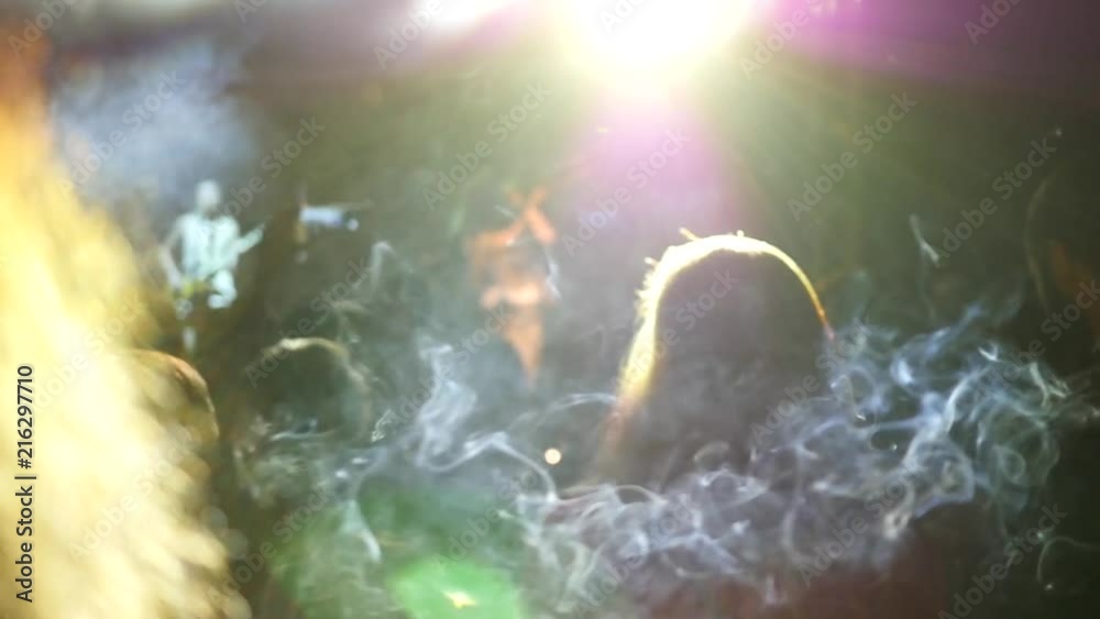 A cigarette smoke silhouette flying in air among crowd spectators on concert lumiere