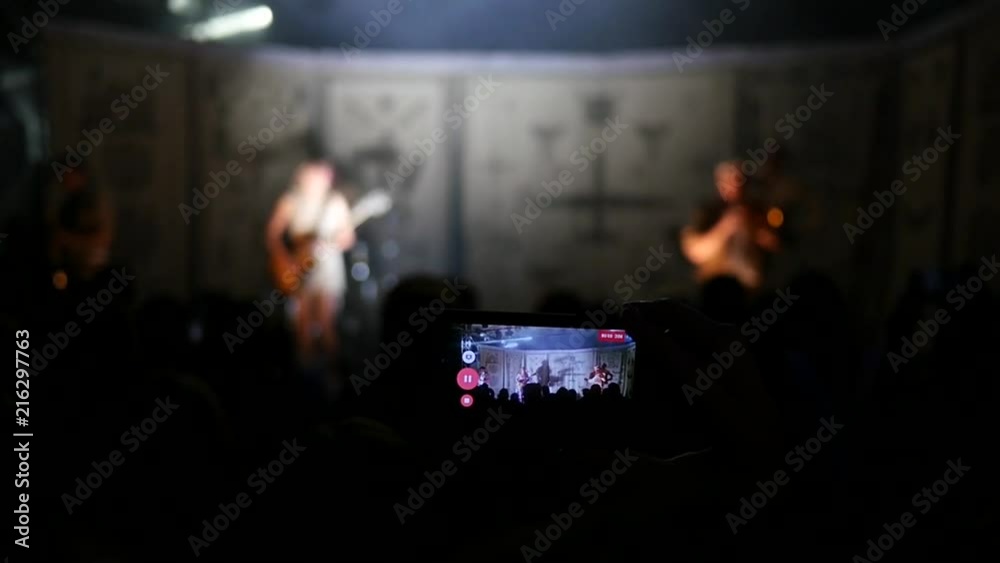 Concert lights lumiere and public fan spectators film video with smart phone