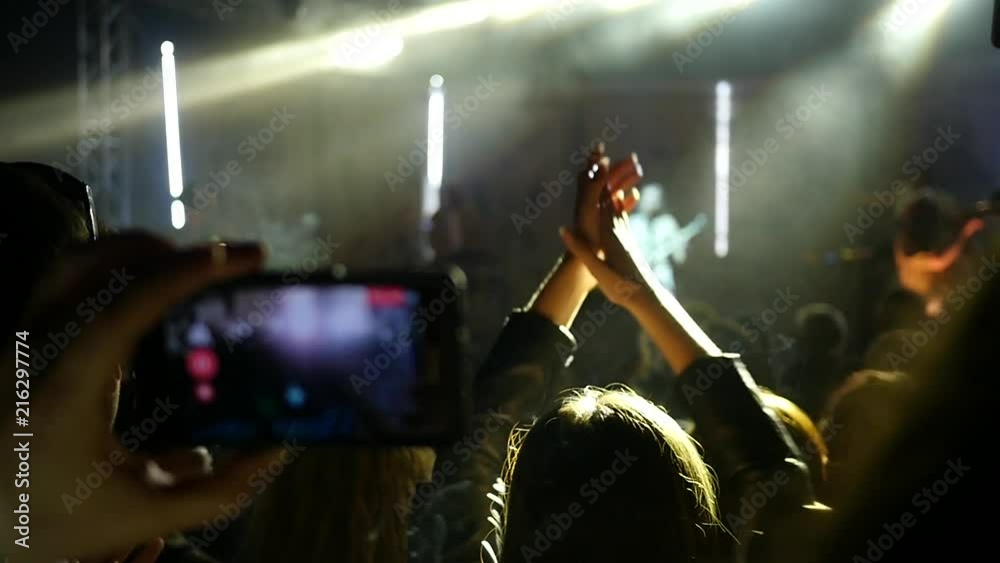 Fan spectator silhouette clapping hands in light lumiere listen to concert