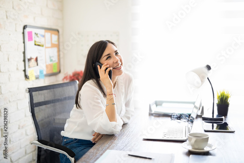 Businesswoman making a phone call from her desk