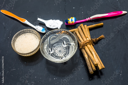 Close up of best and trusted home remedy for Tooth problems and yellow teeth i.e. baking soda with water and normal tooth brush it daily thrice.All ingredients on wooden surface with neem bark.