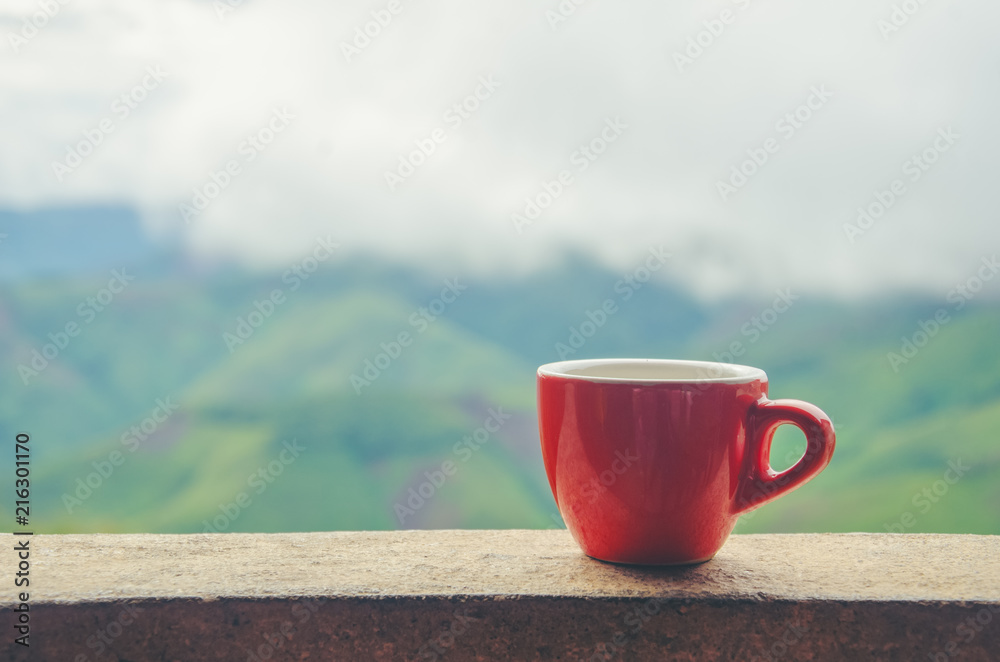 Red coffee mug with green mountain as background in coffee shop in north of Thailand. Red coffee mug with green mountain as background in coffee shop in north of Thailand.