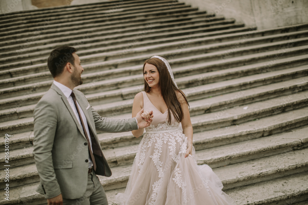 Fototapeta premium Young wedding couple on Spanish stairs in Rome