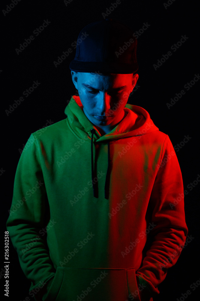 Jugendlicher senkt Kopf mit rotem und blauem Seitenlicht