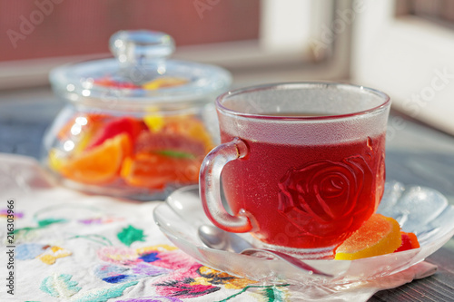 Close up of a morning black tea and colorful marmalades in glass jar on wooden table