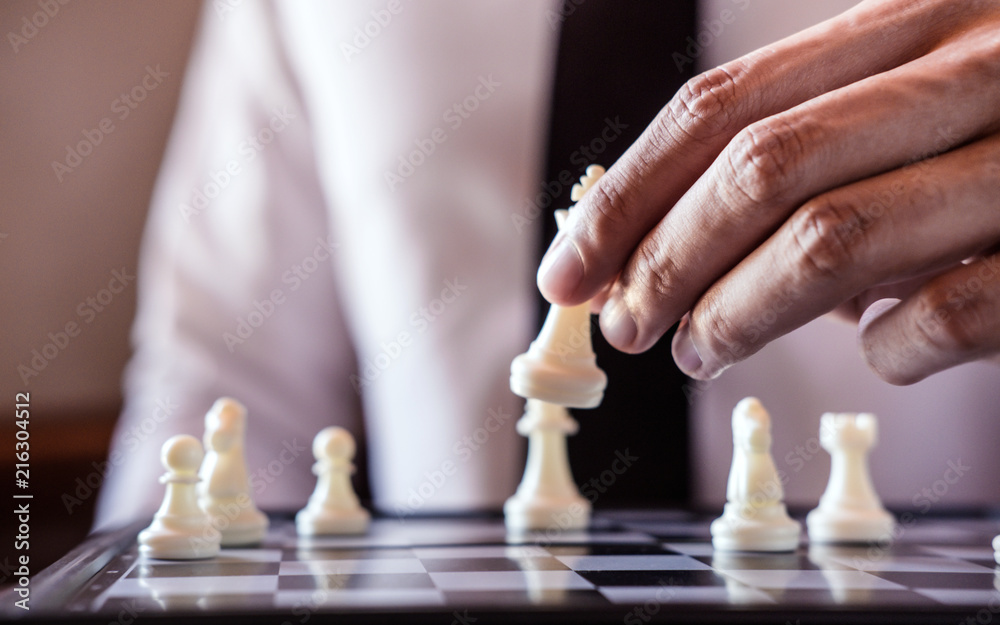 Hand of confident businessman use king chess piece white playing chess game to development analysis new strategy plan, business strategy for win and success Hand of confident businessman use king chess piece white playing chess game to development analysis new strategy plan, business strategy for win and success