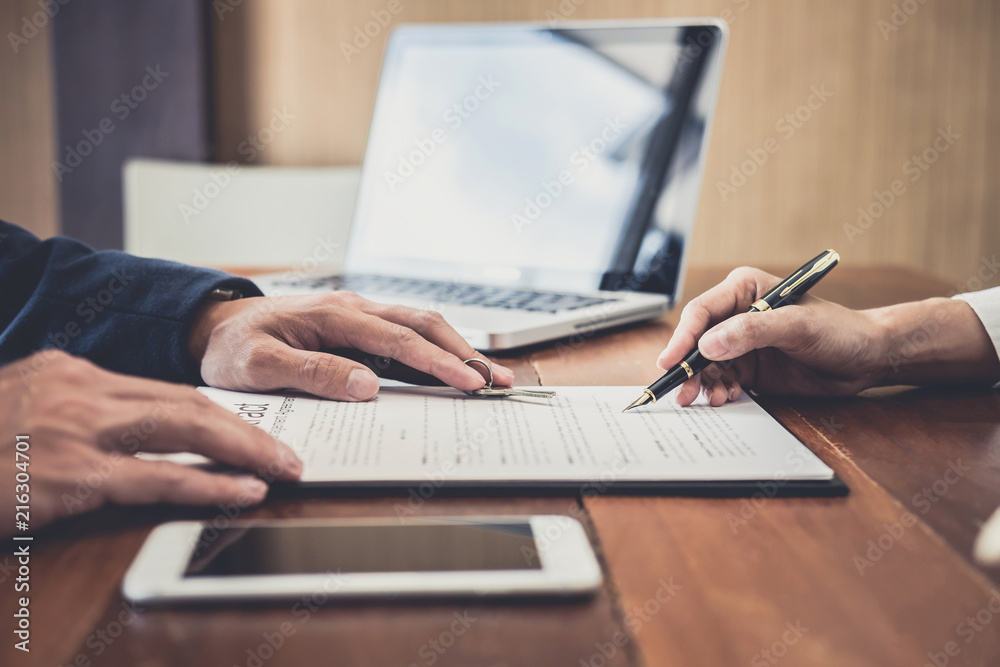 Sales manager filing keys to customer after signing rental lease contract of sale purchase agreement, concerning mortgage loan offer for and house insurance Sales manager filing keys to customer after signing rental lease contract of sale purchase agreement, concerning mortgage loan offer for and house insurance
