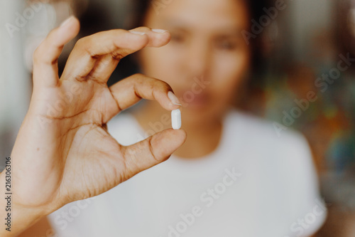 woman holding pills in one hand