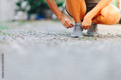 young woman runner tying shoelaces . Sport lifestyle.