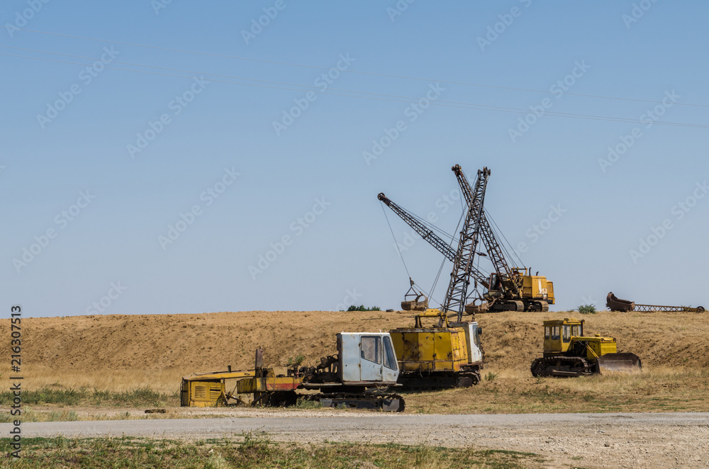 three excavators dragline one bulldozer and one dismantled excavator