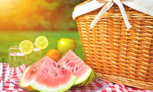 Picnic basket with watermelon on nature