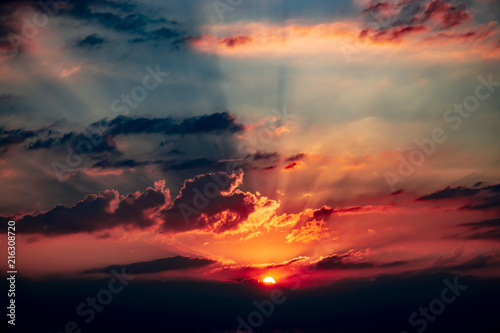 Brilliant sunset with rays of light shining behind the clouds