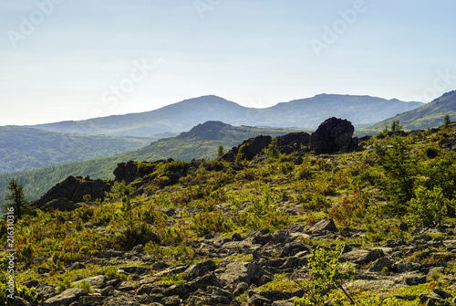 high-mountainous landscape of the Northern Urals in the vicinity of Mount Konzhakovskiy Kamen in a bright sunny day in the atmospheric haze
